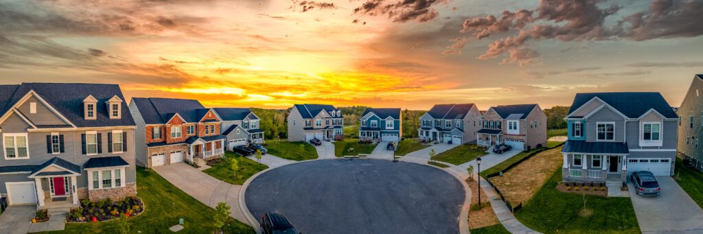 A cul-de-sac of houses with a beautiful sunset in the background.